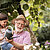 Little girl helping her grandpa watering plants